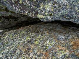 Crack in granite. Narrow entrance to the cave. Fault line or fracture in the rock, erosion, a crack in the stone. photo