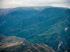 An eagle hovers over a mountain peak using ascending air current photo