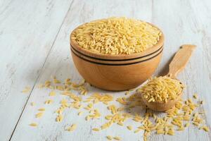Orzo, pasta in dry form in a wooden bowl. photo