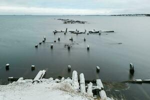 Winter minimalistic landscape with an old ruined pier in the Arctic. Long exposure photo