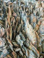 Sharp stones background. Abstract texture of split stone in dark gray color. Big cracked pointed stones closeup. photo