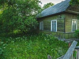 Very old authentic peasant wooden house with green garden, a tra photo