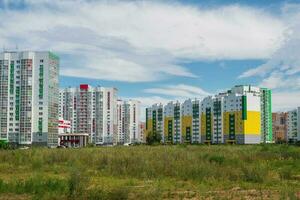 Modern construction, new neighborhood. Modern beautiful new buildings. Colored wall on the background of blue sky. photo