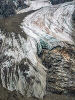 Nature background of dark glacier surface with cracks and scratches. Minimal natural backdrop of icy wall and blocks of ice from glacier close up. Beautiful nature texture of glacial wall. photo