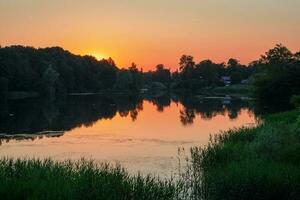 Beautiful sunset on the lake with sunlight. Sunset reflection in a lake. photo