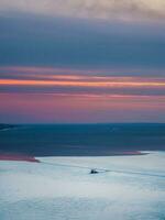 Distant view of an icebreaker crushing ice. Scientific research vessel, breaks its way in the ice of the White Sea. Vertical view. photo