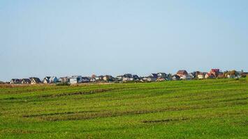 panorámico ver de un moderno cabaña pueblo en un verde campo. foto