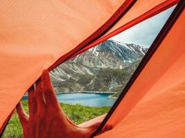 View from inside the tent to high mountains. Hiking and tourism concept. photo