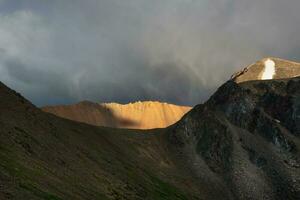 Mystical light in the misty dark mountains. Dramatic sky on mountain peaks. Mystical background with dramatic mountains. Mouth of a volcano. photo