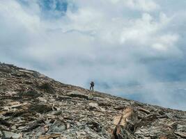 pesado alpinismo en agudo rocas solo trekking en el montañas. viaje fotógrafo estilo de vida, excursionismo difícil pista, aventuras concepto en primavera vacaciones. foto