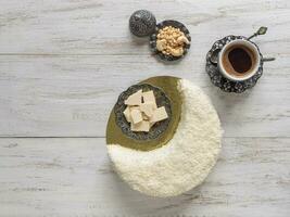 Biscuit cake sprinkled with white chocolate in the shape of a Crescent moon, served with dates and coffee cup photo