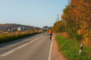 Travel by bike. A male cyclist on a country autumn road. photo