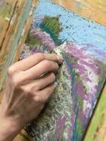 Drawing with pastels close-up. Woman drawing beautiful crocus flowers with soft pastel at table. photo
