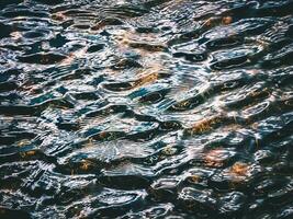 Dark ripples on the surface of the water. Mountain lake background photo