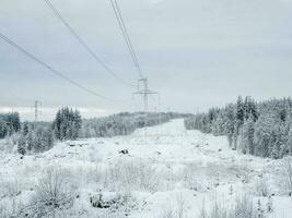 Power towers in the snow-capped northern mountains. photo