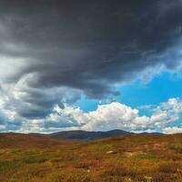 Terrible thunderclouds have hung over the autumn valley. The sky before a thunderstorm with thunderclouds. photo