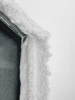 Winter ice window. Icy window to winter in snow. Icy visor over the window. Vertical view. photo