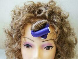 Flexible curlers on the mannequin's head. photo