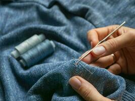 un agujero en el ropa. restauracion de un de punto suéter. foto