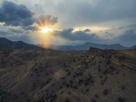 Bright last rays of the setting sun over a mountainous desert plateau. photo