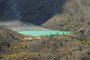 Blue mountain lake in the caldera. Caldera of an extinct volcano is surrounded by a mountain range. Sunny autumn yellow high-altitude plateau. photo