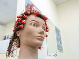 Perm training on a mannequin at the school of hairdressing photo