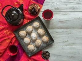 hecho a mano Ramadán dulces son servido con té en el mesa. egipcio galletas foto