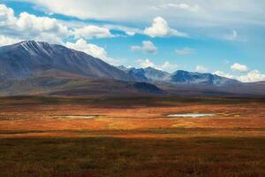 Autumn plateau. Dramatic golden light and shadow on the rock in autumn steppe. High-altitude plateau of Yeshtykol. Altai Mountains, Russia. photo