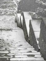 Granite stairs to the frozen river. Ice drift on the river photo