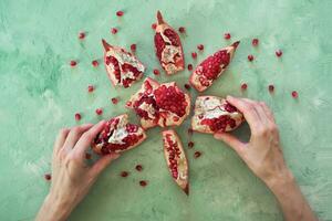 Hands break the pomegranate fruit photo