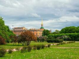 Sunny bright spring in St. Petersburg. Russia. Green lawn in field of Mars. Mikhailovsky Castle. photo