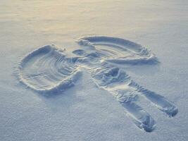 Snow angel made in the white snow. Top flat overhead view photo