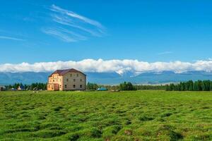 Tourist complex, wooden guest house against the background of snow-covered high mountains. photo