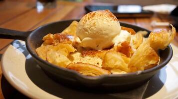 Croissant bread pudding with custard creamy sauce and vanilla ice cream topped with a little bit espresso coffee very delicious dessert present in a large pan. photo