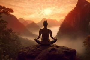 Young woman meditating in lotus position on the top of a cliff at sunset with . photo