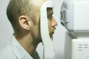 hombre examinando vista en óptico clínica. foto