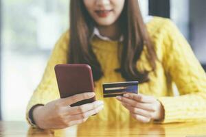 Closeup hands holding credit card and using smartphone. photo