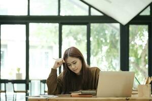 Young collage student using computer and mobile device studying online. photo