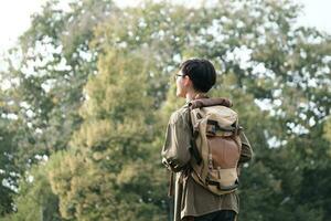 Young man walking with backpacks over natural park background. photo
