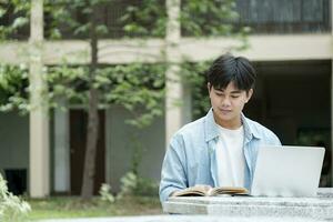 Young collage student using computer and mobile device studying online. photo