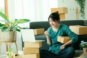 Young happy asian SME business woman use digital checking customer order. photo