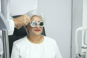 Woman examining eyesight in optical clinic. photo