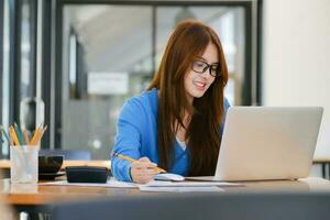 Young collage student using computer and mobile device studying online. photo