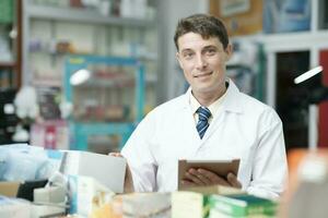 Male pharmacist checking stock inventory in pharmacy. photo