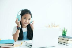 Pretty stylish school girl studying homework during online lesson at home, , study online video call teacher. photo