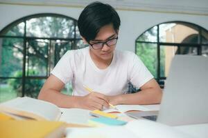 Young Asian male student is preparing to reading a books for exams at university. photo