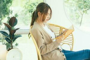 Young collage student reading a book sitting in a chair. photo