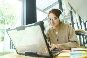 Young female college student uses a computer to access the Internet for online learning. photo