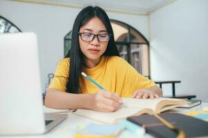 Young woman study in front of the laptop computer at home. photo