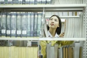 Student choosing and reading book at library. photo